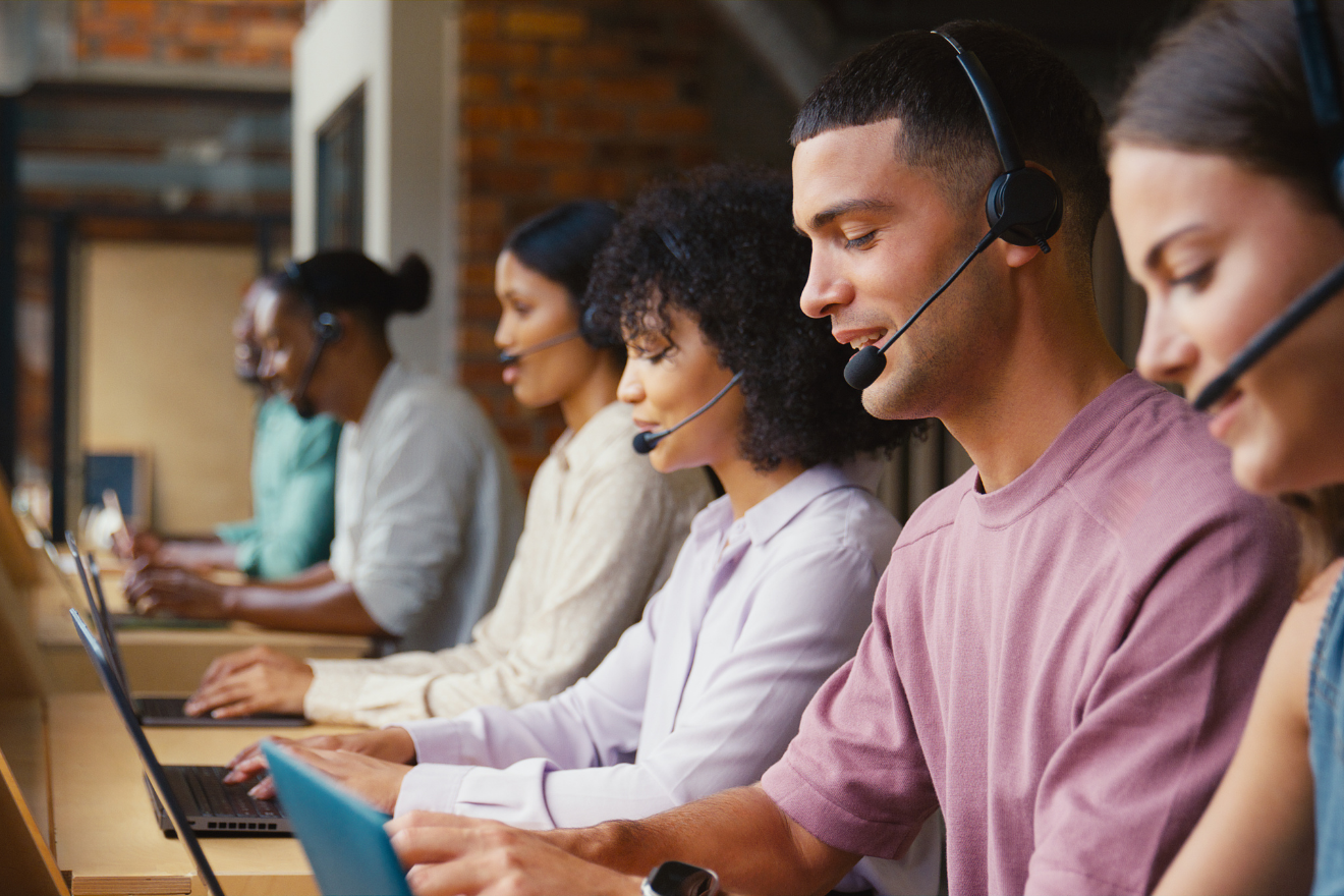 Customer support team working with headsets in an office environment providing QuickBooks assistance.
